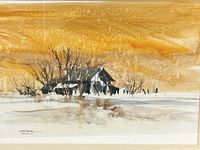 Close-up photo of the watercolor painting showing the cabin in snowy landscape under a golden sky.