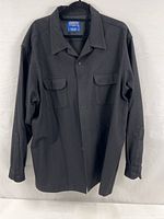 Black Pendleton board shirt displayed hanging, showing front with button closures and chest pockets.