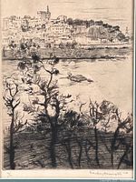Close-up photo of etching artwork showing European waterfront town with trees in foreground.
