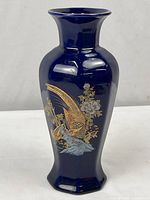 Full photo of blue vase with gold and multicolor pheasant and floral decoration on a hexagonal base.