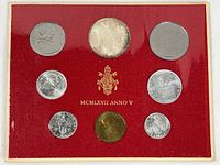 Full view of the 8 Vatican coins on red cardboard holder with protective plastic sleeve, showing various silver and gold-colored coins with Vatican crest and inscription.
