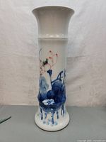 Front view of 19-inch white porcelain trumpet vase with blue and red lotus decoration.