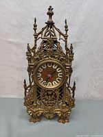 Front view showing overall ornate filigree brass case and round dial