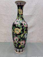 Full image of the cloisonné vase showing floral patterns on a black background with some white and green details at base and neck