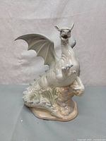 Front view of the white porcelain dragon figurine showing wings raised and detailed claws.