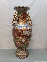 Front view of the full Japanese Satsuma vase showing bird motif, scalloped rim, and dragon-shaped gold handles.