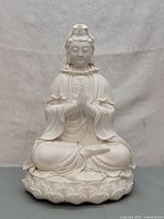 Front view showing the full statue of Guanyin, highlighting the seated posture and lotus base.