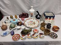 Full table view with various Chinese porcelain and ceramic items including vases, plates, figurines, and boxes.