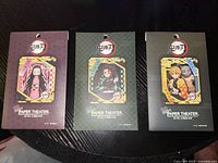 Photo showing all three sealed Demon Slayer Paper Theater sets featuring Nezuko Kamado, Tanjiro Kamado, and Zenitsu Agatsuma with Inosuke Hashibira on packaging.
