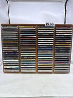 Front view of wooden CD holder filled with CD jewel cases in four columns.