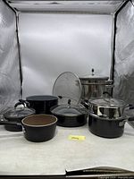 Full view of all cookware pieces including pots, pans, lids, and inserts.