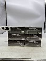 Six boxes of NitriDerm Ultra White nitrile exam gloves stacked in two rows, each box labeled with size Medium and indicating 100 gloves per box.