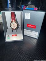 Timex watch in original box with battery label visible on packaging and watch displayed with leather strap and pearl dial