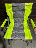 Front view of the green and grey heated armchair showing the fabric, armrests, and metal frame.