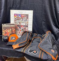 Overview photo showing the entire lot including the bag, hat, ornament, book and framed print.