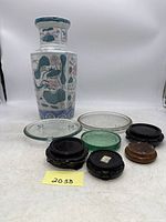 Full lot showing the 14-inch painted ceramic vase, three glass candle plates, and four carved wood footed base stands of varying sizes and designs.