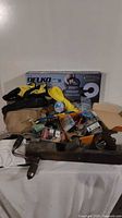 Front view showing assortment of tools including a hand plane, gloves, yellow rope, and Delko Tools box