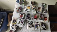 Photo showing numerous stacks of hockey trading cards arranged on a table, depicting mixed brands and players from various teams and years.