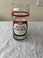 Front view of a clear Molson Canadian beer glass showing the logo and design details.