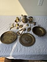 Overview of all brass antique collectible items arranged on a cloth.
