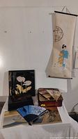 Photo showing full set with the wall scroll hanging, lacquer boxes, fans, and paper prints arranged on surface