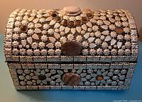 Front view of the rounded silver metal chest with semi-precious stones and floral pattern engraving
