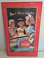 Plaque mounted glossy Coca-Cola poster showing vintage artwork with people enjoying Coke and bold text.