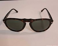 Front view of tortoise shell Persol 649 sunglasses on white background