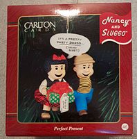 Close up of Carlton Cards Nancy and Sluggo ornament box showing the characters with a gift and speech bubble