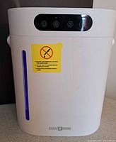 Front view of the white Paris Rhone humidifier showing control panel and water level indicator with caution sticker.