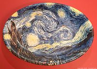 Oval Vincent Van Gogh Starry Night serving platter photographed on red background. Shows design and overall condition.