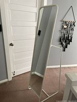 Front view of the freestanding full length mirror with white metal frame and angled base support.