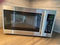 Front view of Hamilton Beach microwave oven showing stainless steel door with window and digital control panel