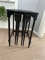 Main square table from front showing folded round tables nested inside brackets beneath