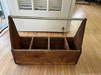 Front angled view of the empty wooden toolbox showing metal handle and four compartments inside with 'Encyclopedia Americana' stamp.