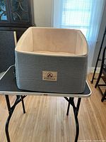 Front view of grey and beige pet booster seat with Firepaw label on front.