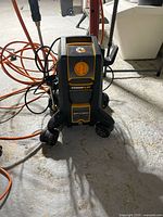 Front view of the compact Powerplay Spyder pressure washer showing the control dial and wheel base.