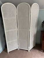 Full view of the white wicker and wood 3-panel folding room divider screen, standing unfolded.