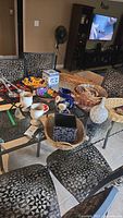 Table setup showing stoneware goblets, blue ceramic box, colorful ceramic bowl, woven baskets, other kitchen and serving items