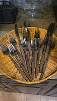 Teak-handled forks and knives arranged in basket