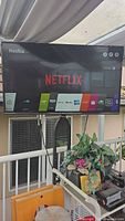 Front view of LG TV turned on showing Netflix interface with app icons on screen.