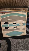 Photo showing vinyl record album Split Enz Waiata with geometric music note design on cover