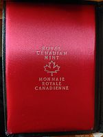 Front cover of the red satin interior with Royal Canadian Mint and Monnaie Royale Canadienne embossed in silver with maple leaf crest.