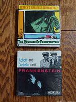 Both sealed 8mm film boxes showing front covers; one for The Revenge of Frankenstein with colorful monster illustration, second for Abbott and Costello Meet Frankenstein in black and white.