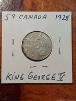 Photograph of the coin inserted in a cardboard holder with handwritten text noting '58 CANADA 1928 KING GEORGE V'.