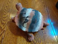 Top view of terracotta tortoise bowl showing Kokopelli figure painted on shell with natural terracotta color and black paint detail.