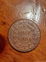 Obverse side of the Half Anna coin showing 'HALF ANNA' text and laurel wreath with English and Persian script inscriptions.