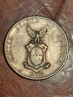 Reverse side of 1945 Philippines 10 Centavos coin showing Philippines coat of arms with eagle on top, the year 1945, and 'United States of America' inscription with D mintmark