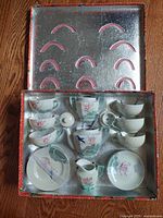 Full view of the children's tea set in original box showing cups, saucers, teapot, sugar bowl, creamer, and lid in iridescent bluebird-themed porcelain lusterware