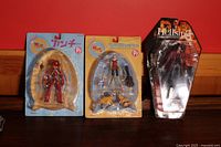 Full view of three anime figures in original packaging, placed against red background.
